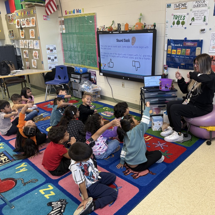 Students listening to a lesson on the classroom carpet