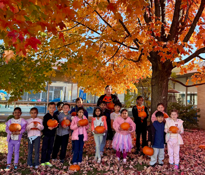 Class photo outside with pumpkins