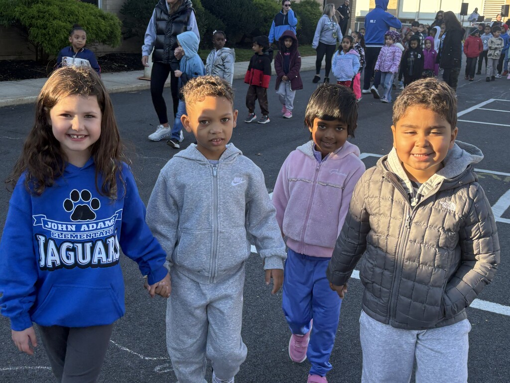 students holding hands outside
