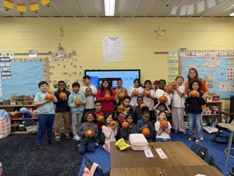 Students showing off their decorated pumpkins