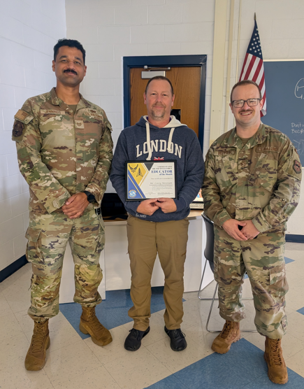Two members of the United States Air Force presenting Corey Newnum as the Air and Space Force Educator of the Month for our local recruiting area!