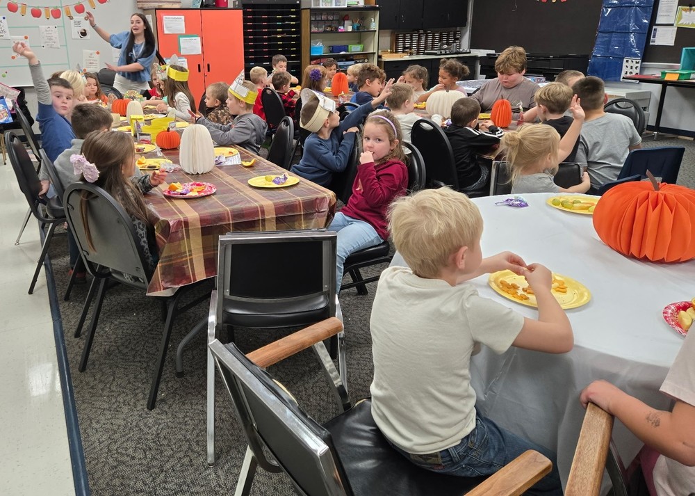 students sitting at tables enjoying Thanksgiving feast