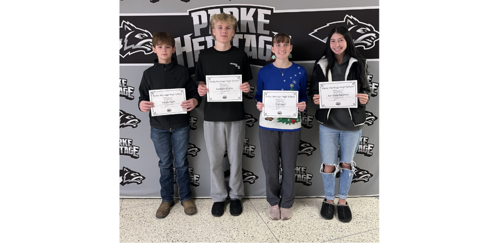 four students standing in front of a back drop holding certifiates