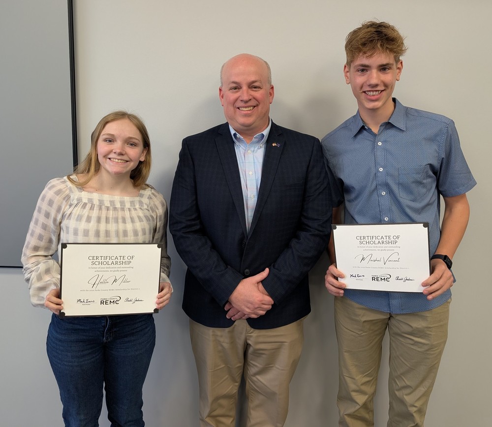 three people standing in a row with two of the holding certificates