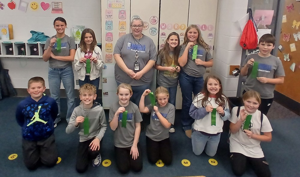 two rows of students sitting and standing and holding ribbons