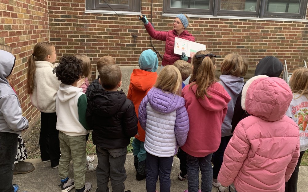 a teacher telling a group of students about planting bulbs