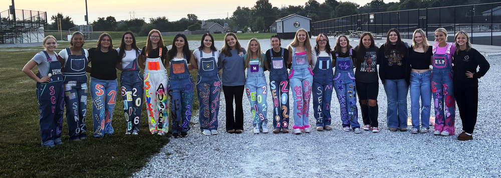 senior girls wearing their Bib overalls and standing in a line