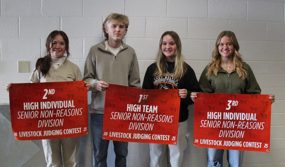 four students standing in a line holding banners