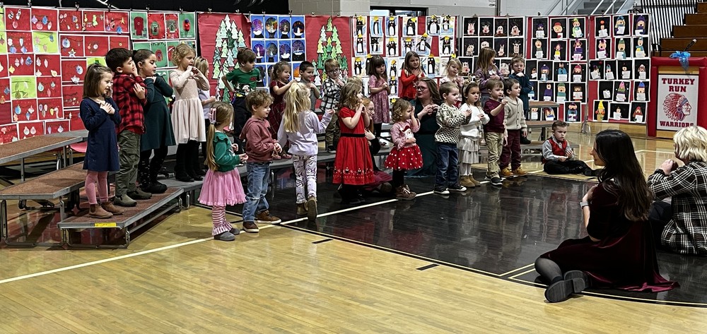 photo of preschool students standing on bleachers and performing Christmas songs