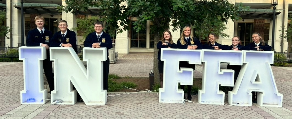 eighth FFA members standing behind the letters IN FFA