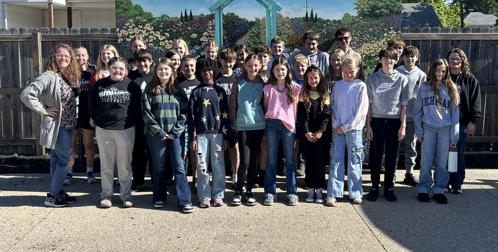 students standing in three rows in a group