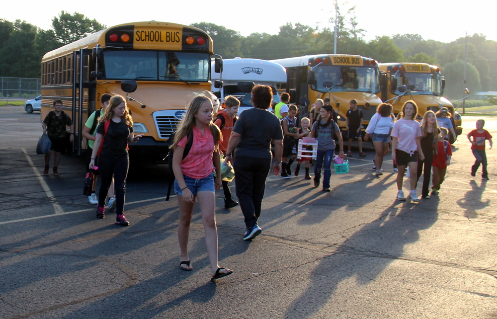 students leaving the bus to enter the school