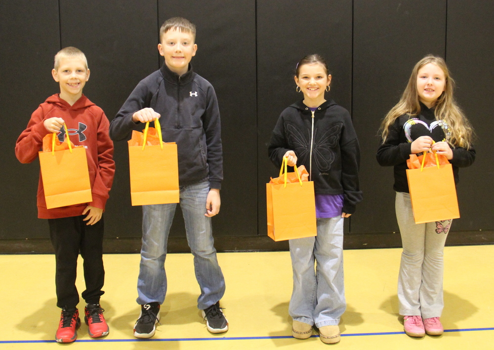 four students holding gift bags