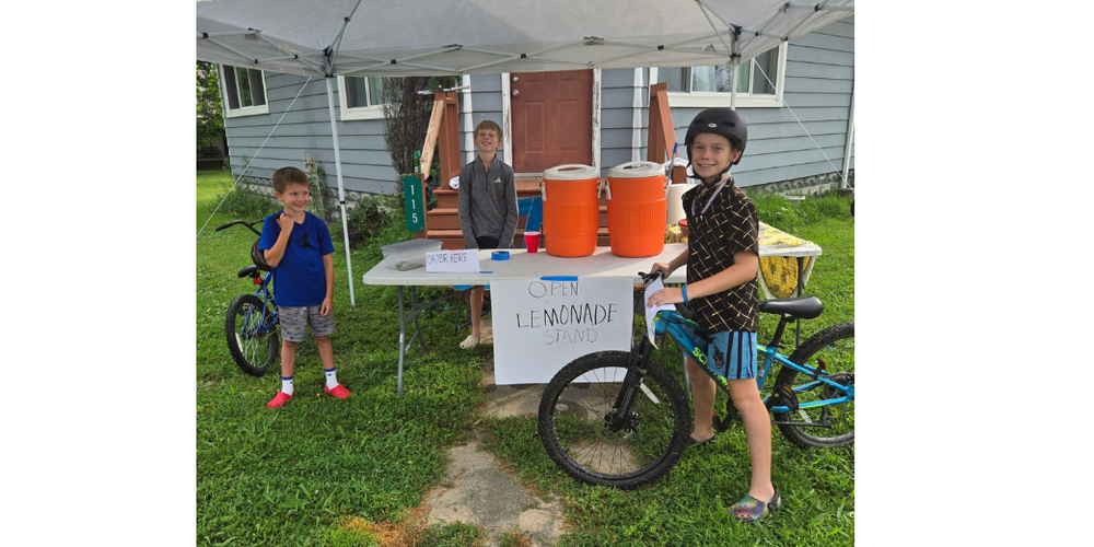 three boys selling lemonade at a lemonade stand