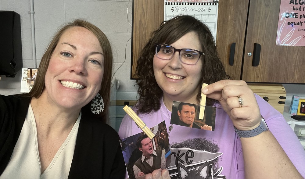 two teachers holding photos