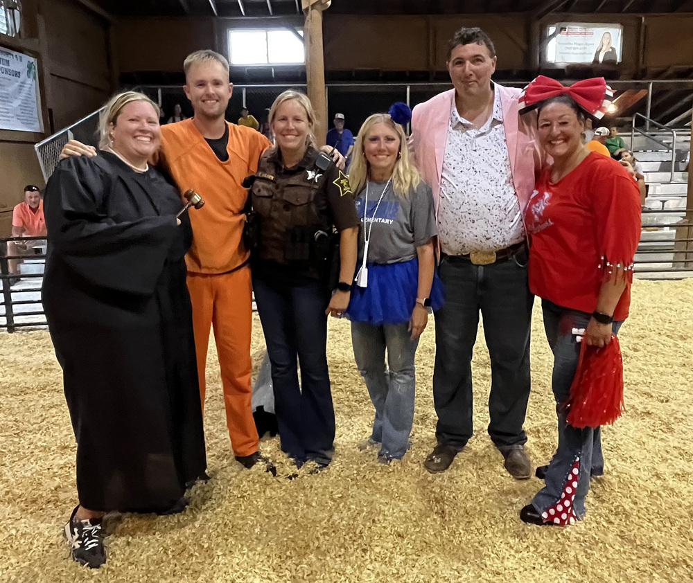 six staff members in costumes for the celebrity showmanship contest at the county fair