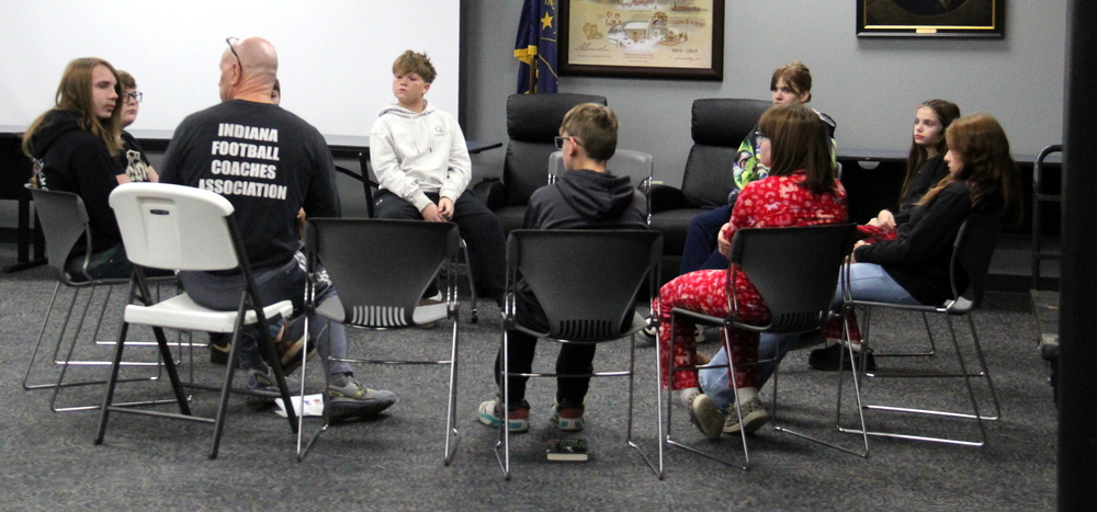 students and a teacher sitting in a circle