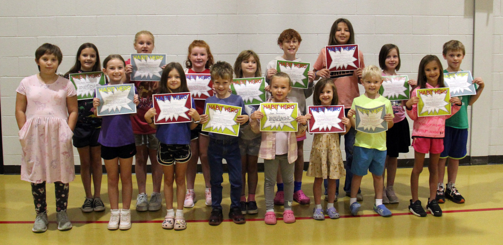 two rows of students standing and holding certificates