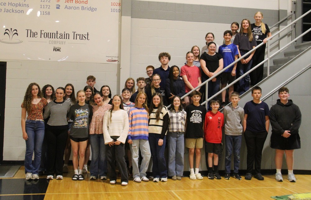 students standing on steps and in a group in the gym