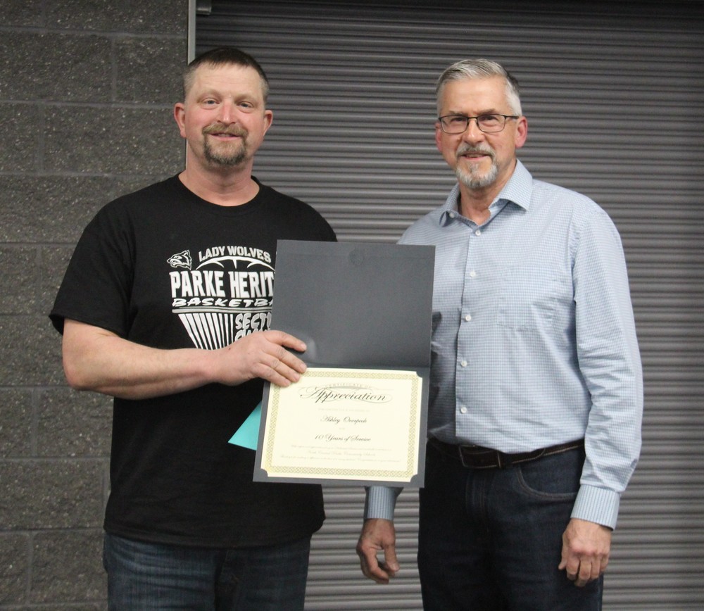 two men standing with one of them presenting a certificate to the other man