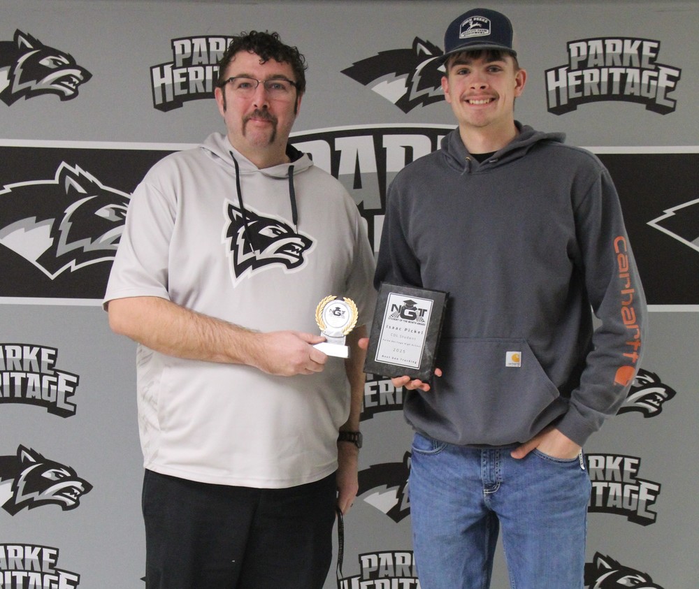 two men standing in front of a backdrop and holding awards