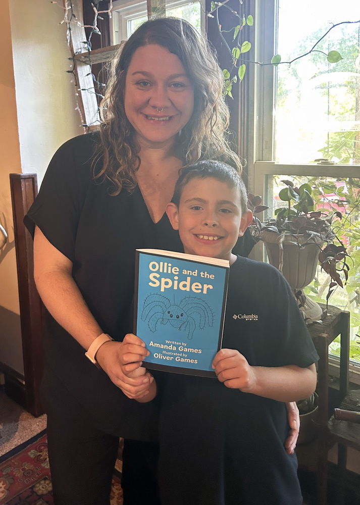 photo of Amanda Games and Oliver holding their book "Ollie and the Spider"