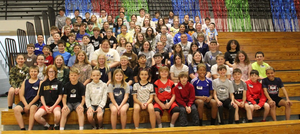 students sitting in several rows of bleachers
