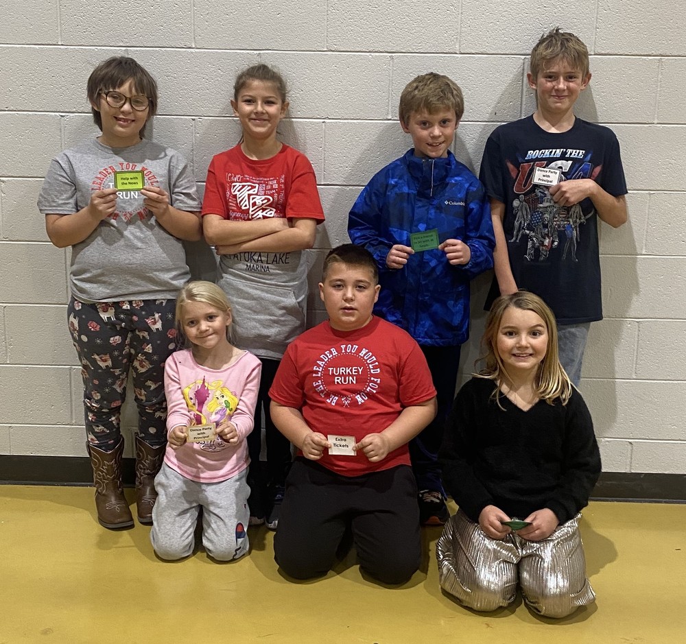 seven students sitting or standing and holding their Leader Lotto prize