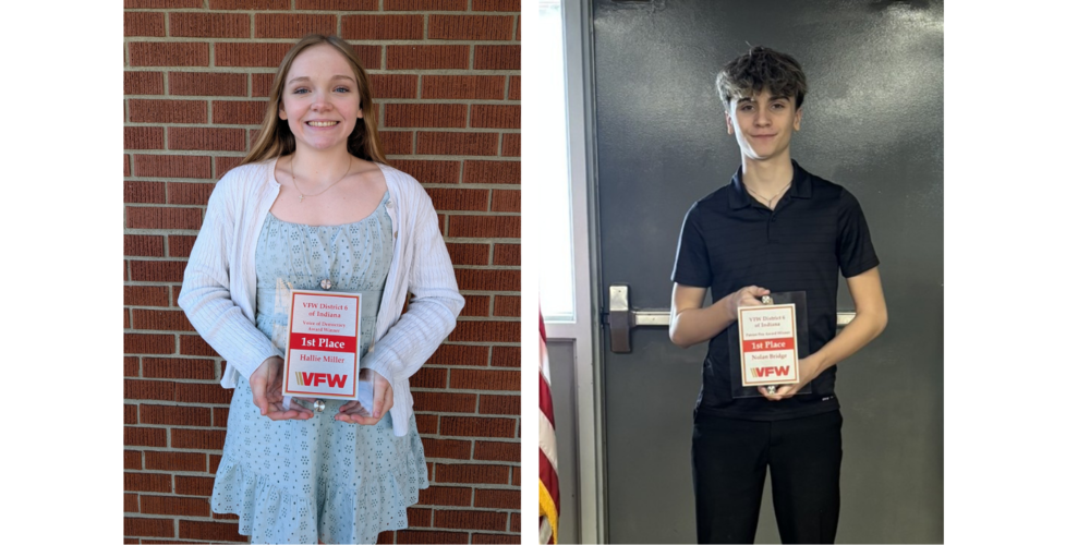 two students holding plaques