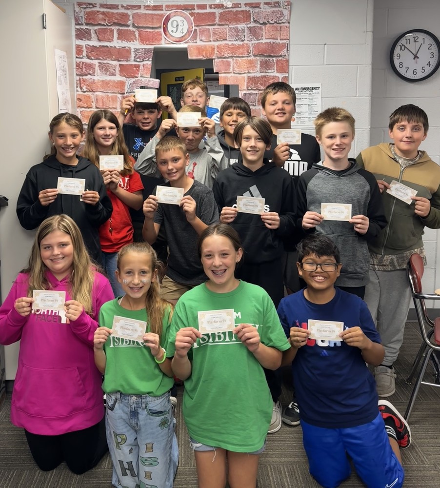 several students standing together holding their Hogwarts train tickets