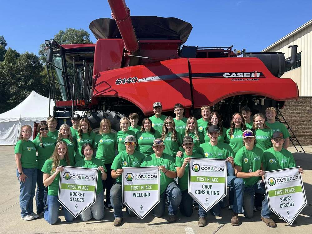 photo with a combine and rows of students sitting, standing and four groups holding first place banners