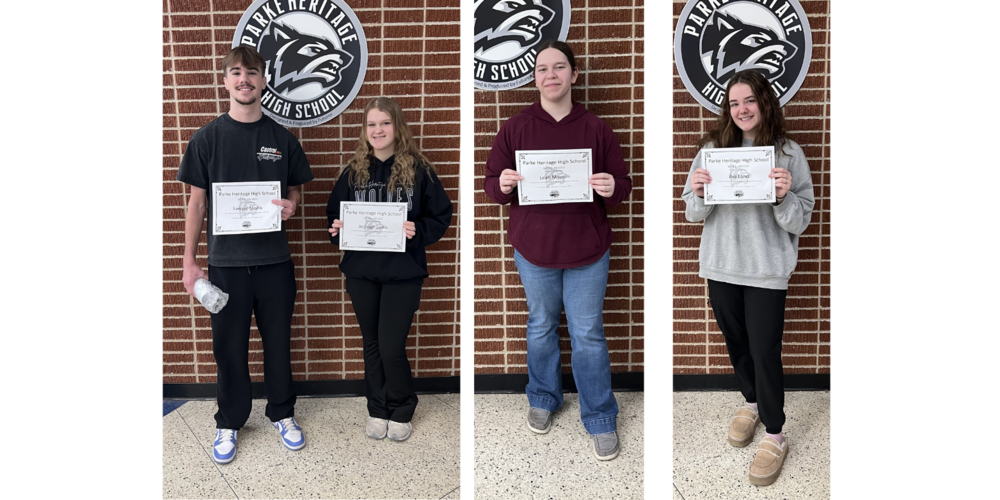 four students standing in a row holding certificates