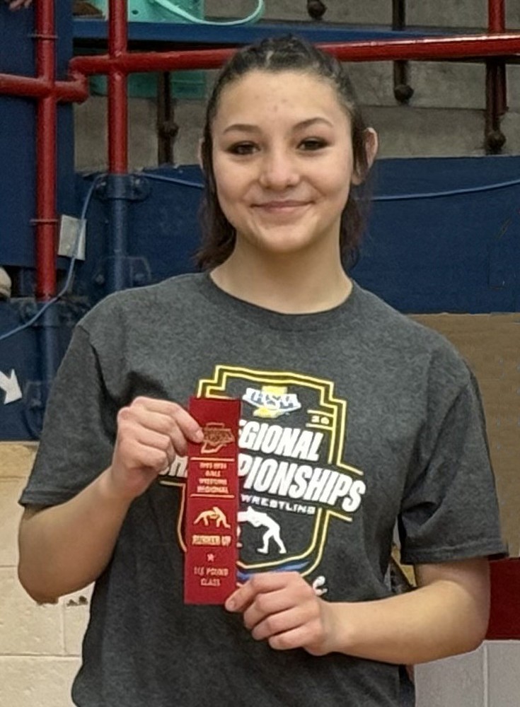 photo of a girls wrestler holding a second place ribbon
