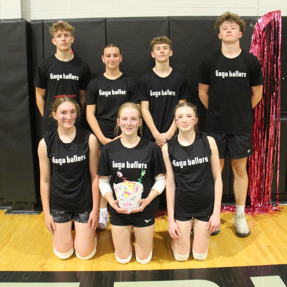 seven athletes sitiing or standing in the gym