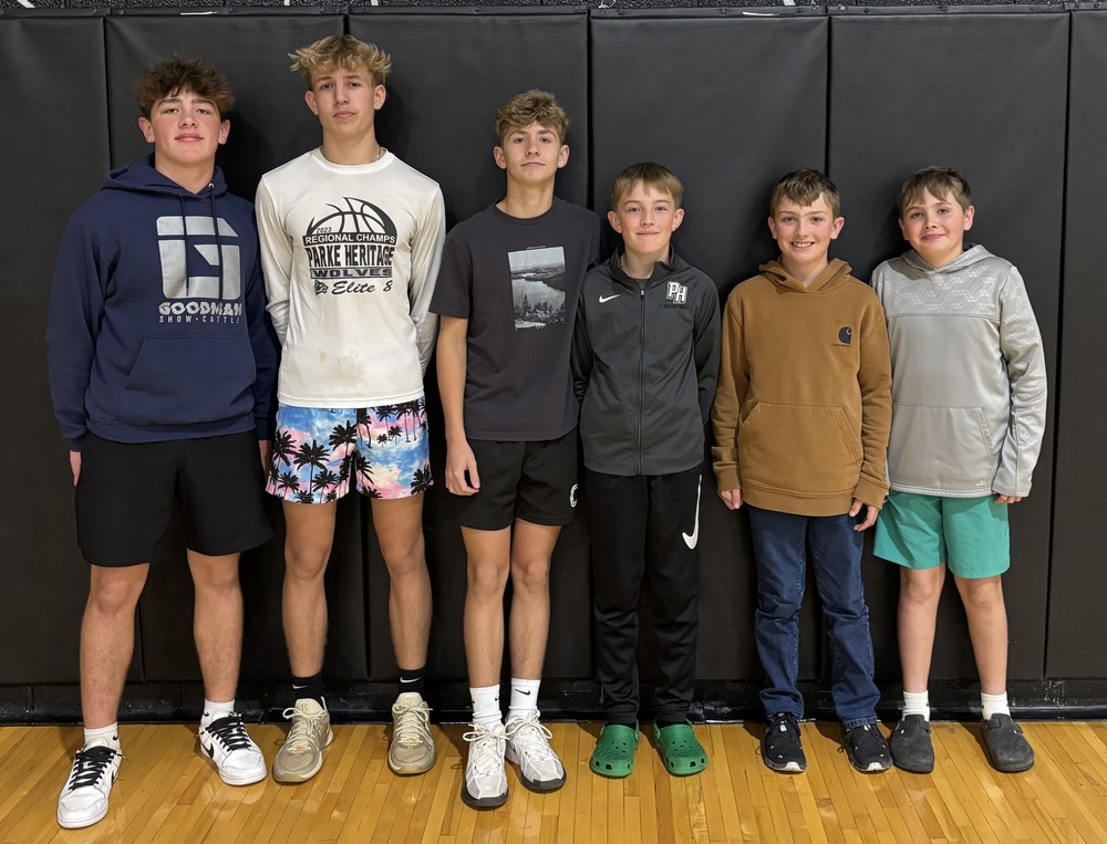six boys standing along a backdrop