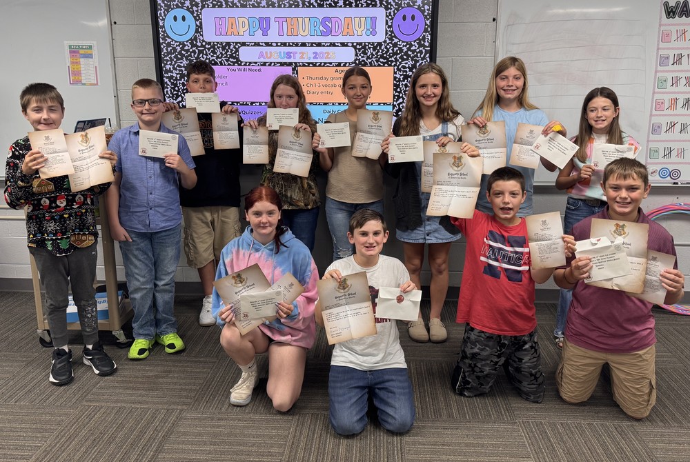 students sitting and standing and holding their Hogwarts letters