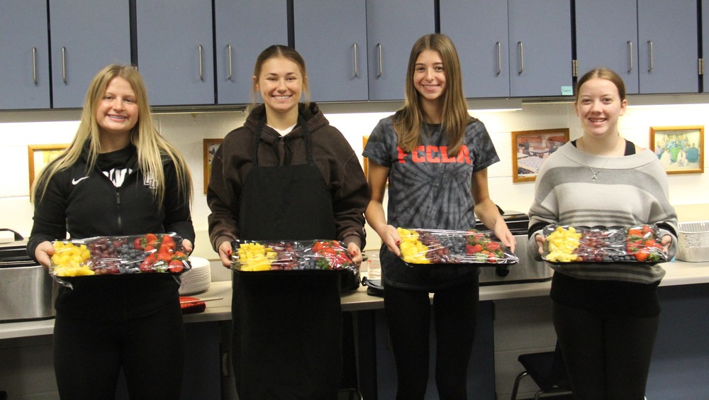 four girls holding fruit trays