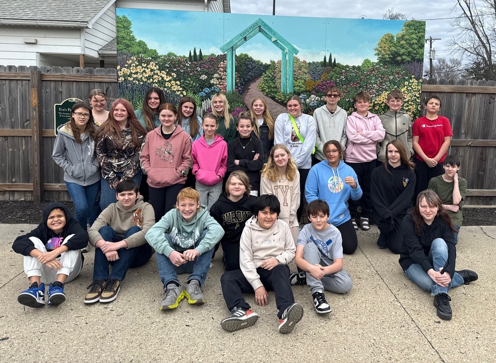 group of students sitting, kneeling or standing at the CANDLES Museum