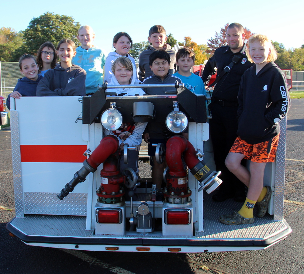 students standing in a fire truck bucket