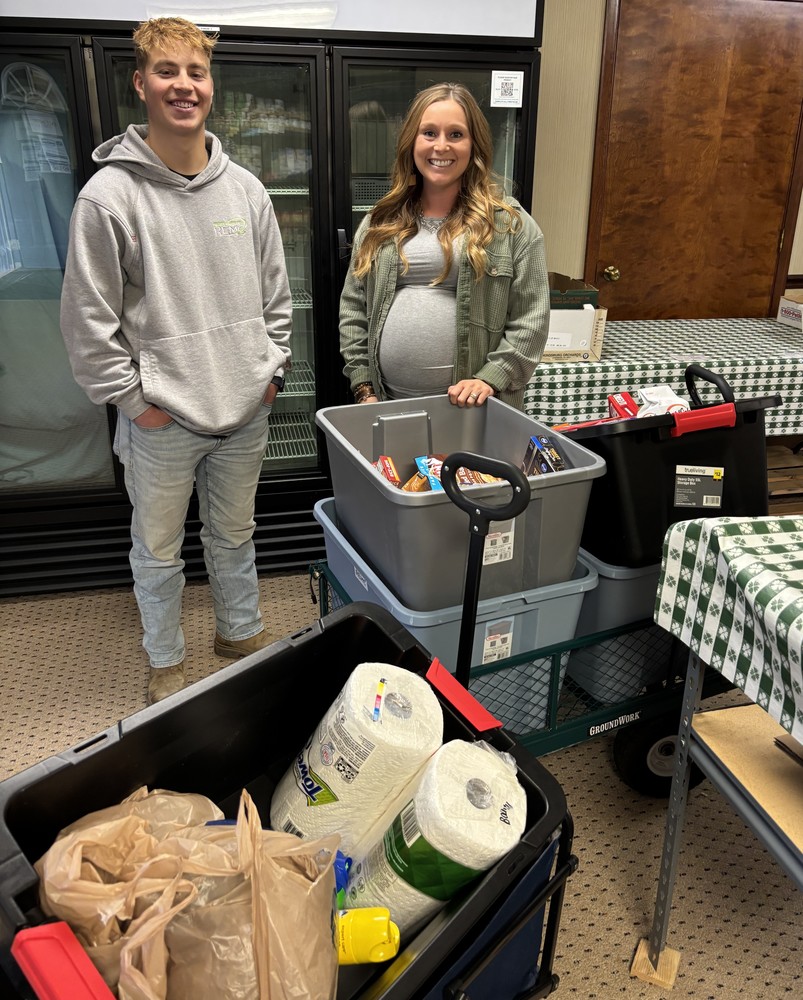 two people standing with food donations for food pantry