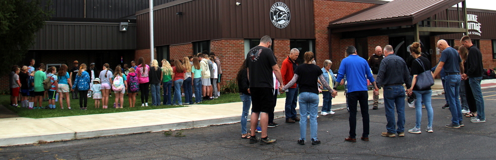two groups gathered in circles holding hands for a time of reflection