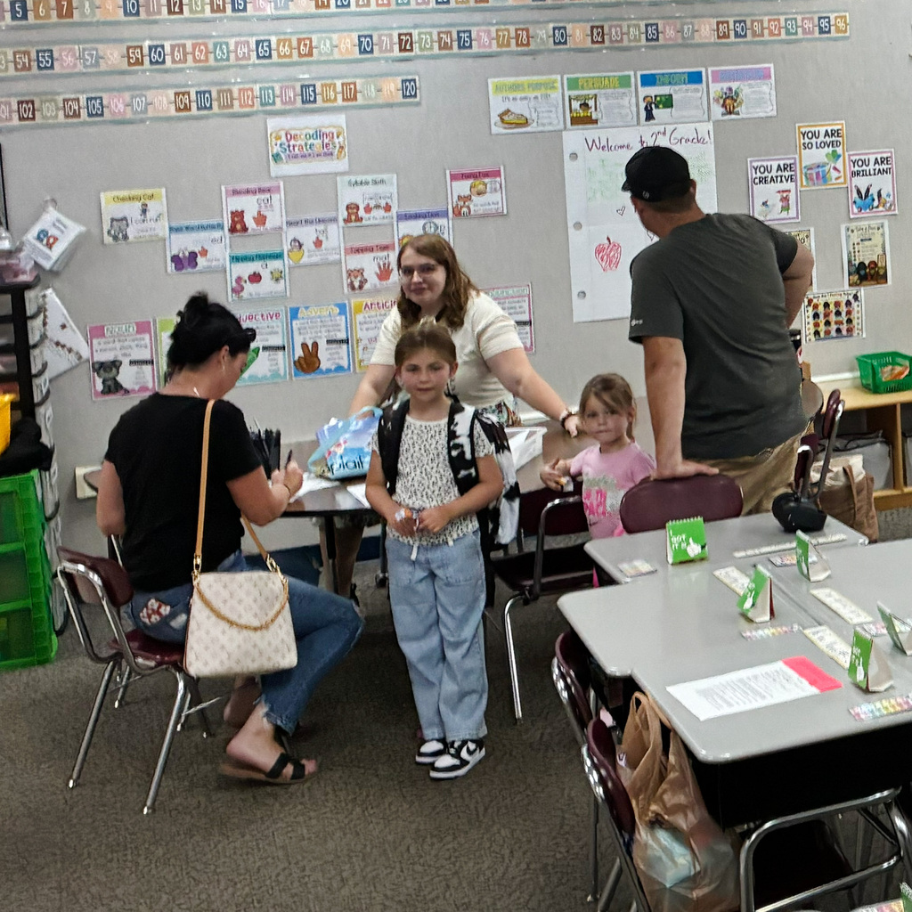 Students and parents in the classroom getting setup for the school year.