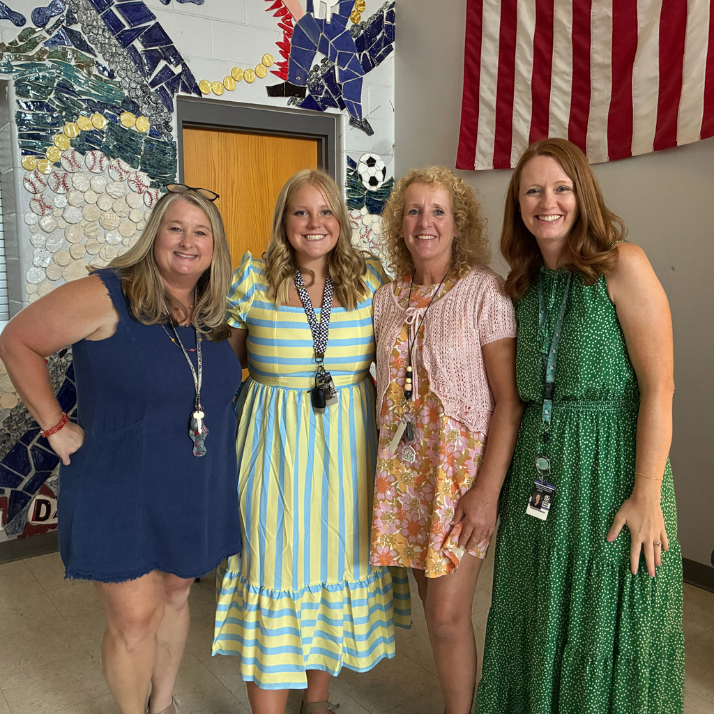 4 teachers smiling/posing for a photo on Back to School night.