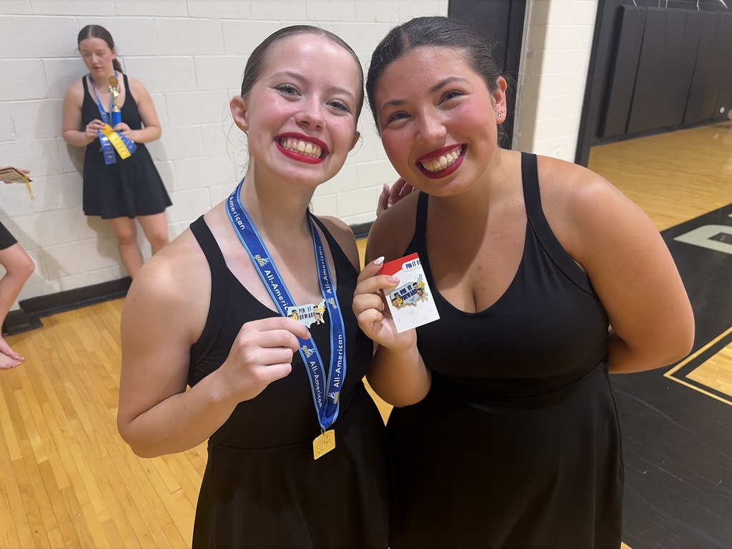Two girls smiling, posing for a photo with their pins from UDA Camp this summer 2026.