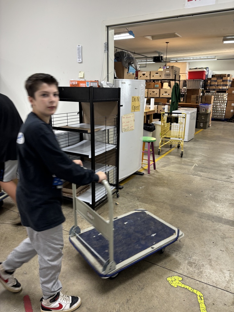 Photo of a student rolling a cart to help at the food pantry for volunteer hours. 