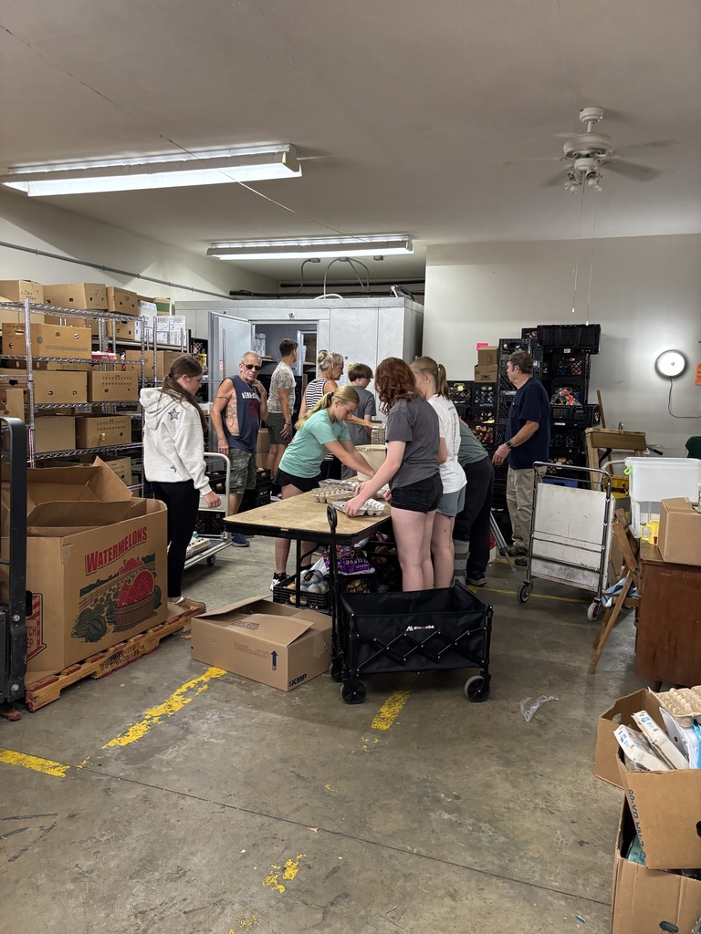 Photo of multiple students helping work for the food pantry for volunteer hours. 