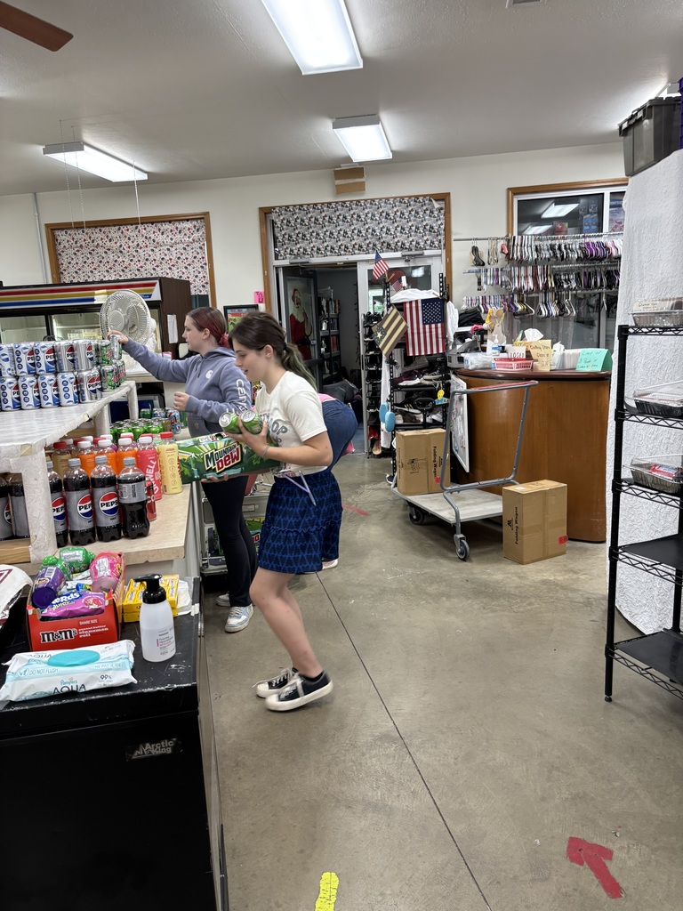 Photo of two students stocking soda at the food pantry for volunteer hours. 