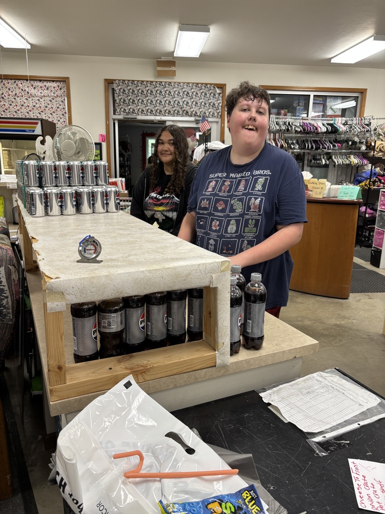 Photo of two students stocking soda, for the food pantry, for volunteer hours.