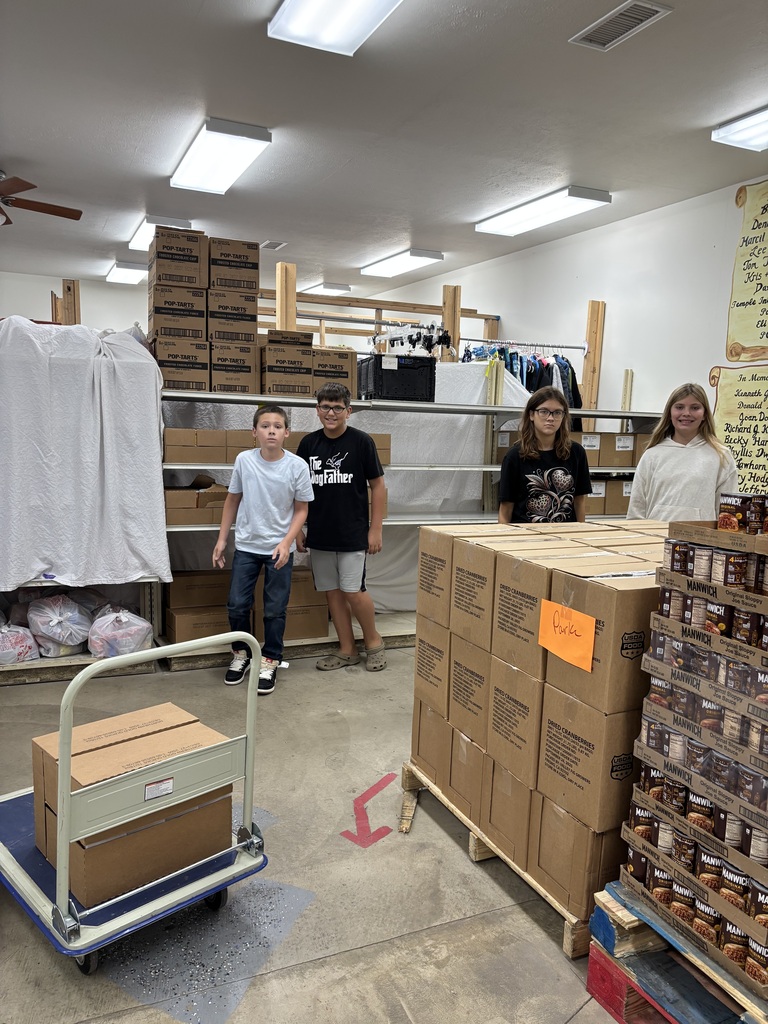 Photo of 4 students getting ready to help at the food pantry for volunteer hours. 