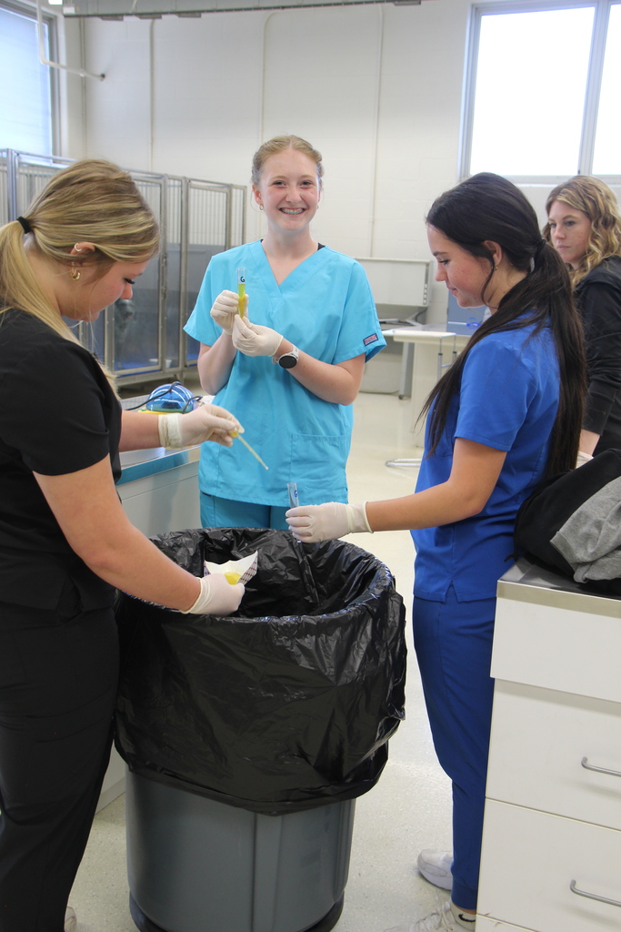 3 students holding urine samples, getting ready to do a urinalysis.